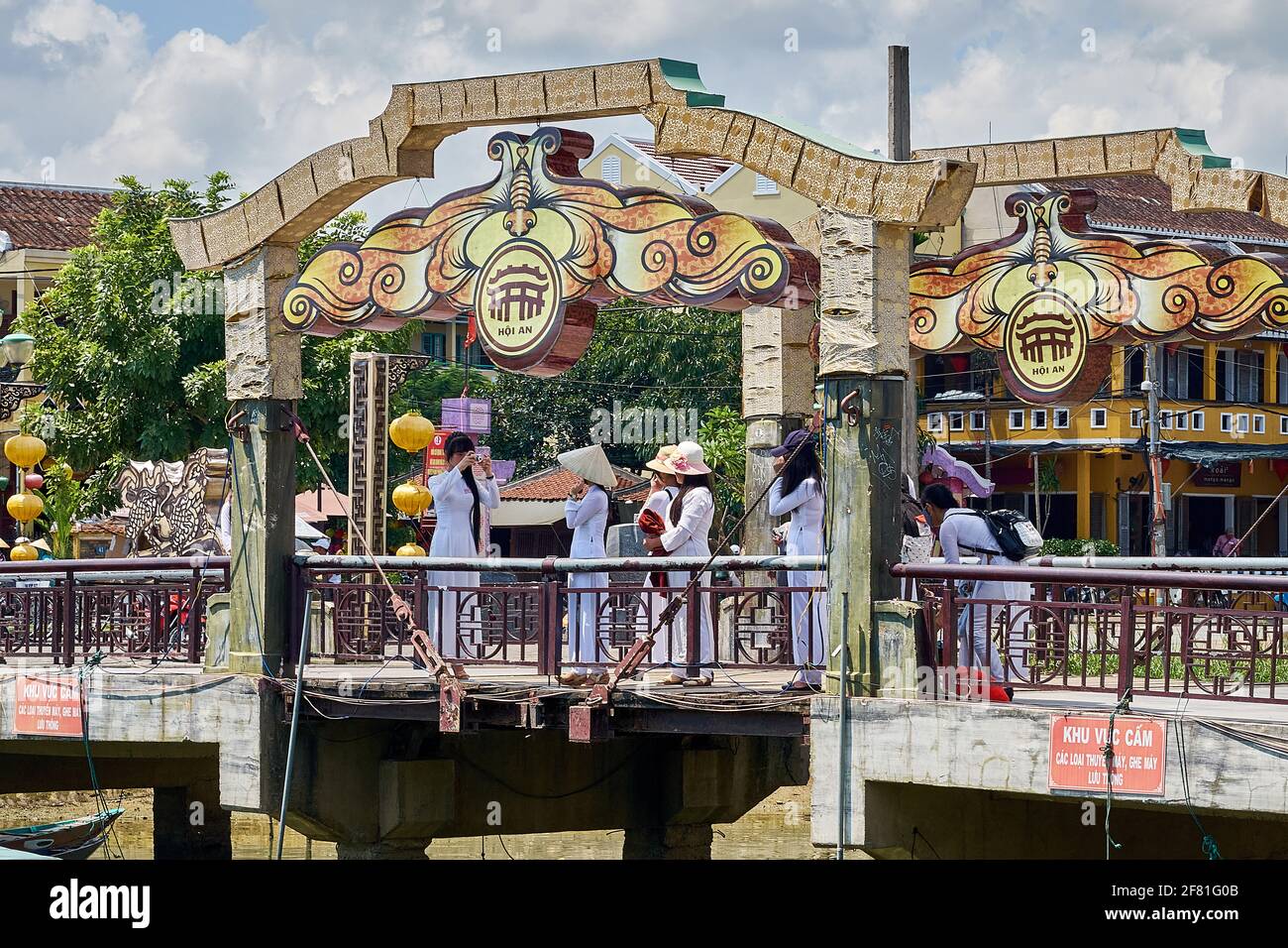 Groupe de femmes vietnamiennes portant l'Ao Dai traditionnel prenant des photos sur le pont des lumières (Cau an Hoi) à Hoi an, Vietnam Banque D'Images