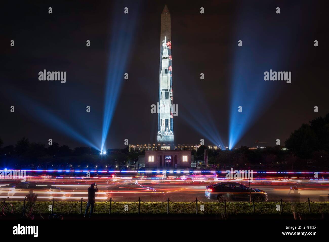 Les lumières de la police traversent la 15e rue en face du Washington Monument alors que la fusée Saturn V, Go for the Moon, est exposée. Banque D'Images