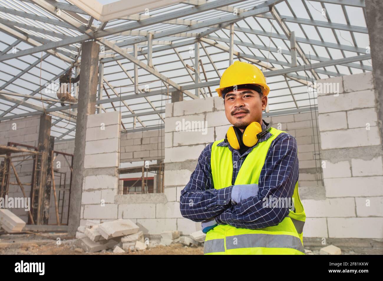 Portrait de l'ingénieur de construction technicien travailleur, ingénieur civil vérifiant la structure du toit de la maison inachevée sur le chantier de construction, Maison c Banque D'Images