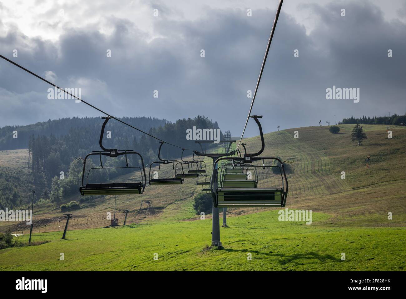 Télésiège au sommet de la montagne. Remontée mécanique vide dans la station de ski de Mala fatra, Slovaquie au printemps. Ciel nuageux Banque D'Images
