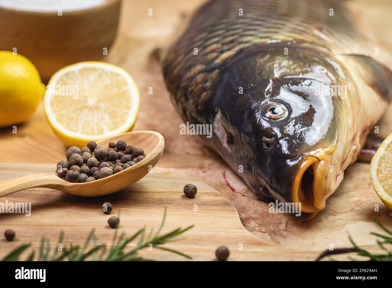 Carpe poisson d'eau douce sur table. Préparation d'aliments sains. Assaisonnement aux herbes et citron Banque D'Images