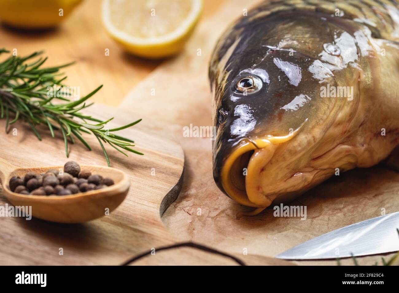 Poisson-carpe sur table. Préparation d'aliments sains. Assaisonnement aux herbes et citron Banque D'Images
