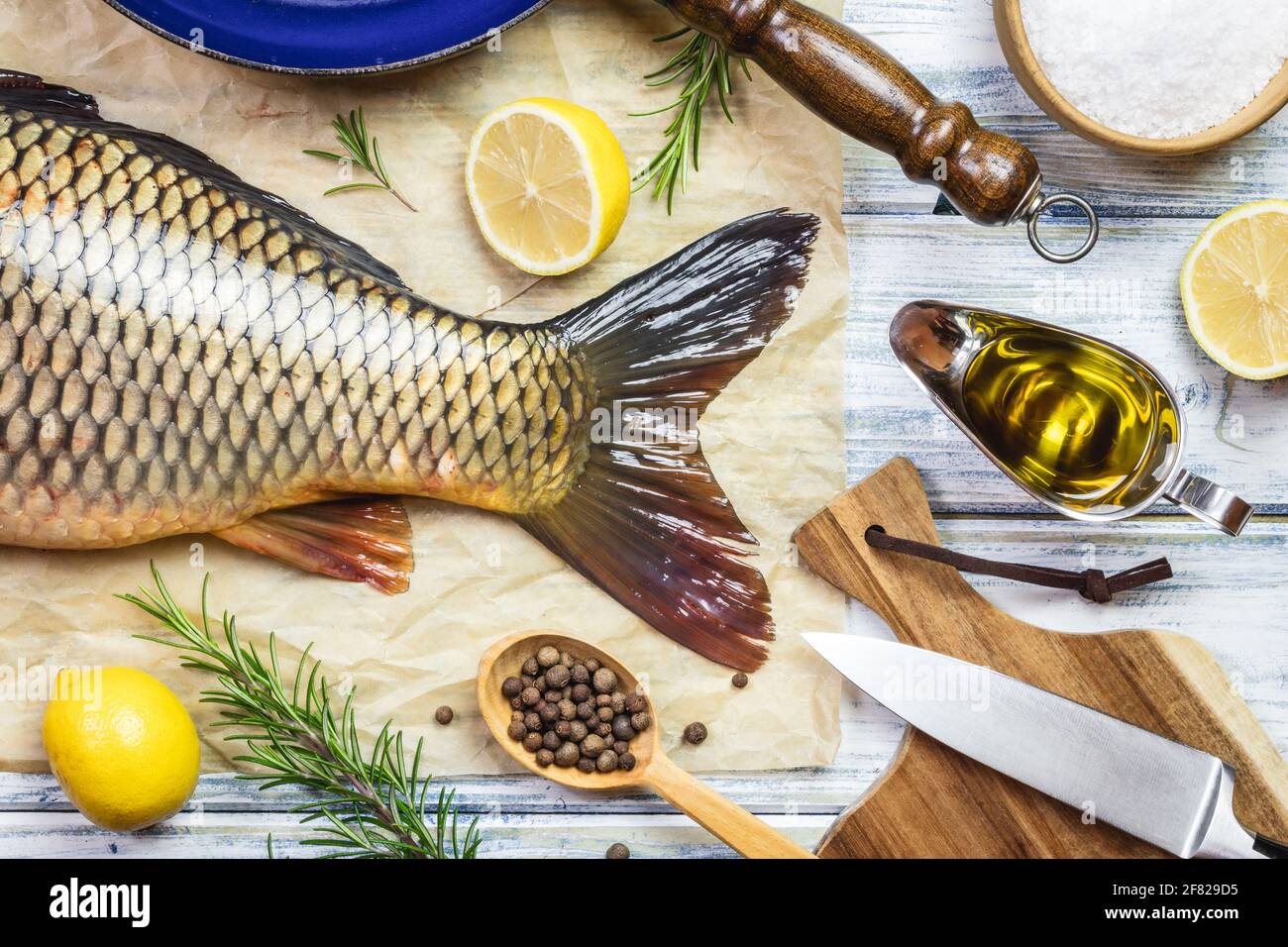 Poisson pour la cuisson. Carpe et ingrédients sur table blanche. Préparer des aliments sains. Pose à plat Banque D'Images