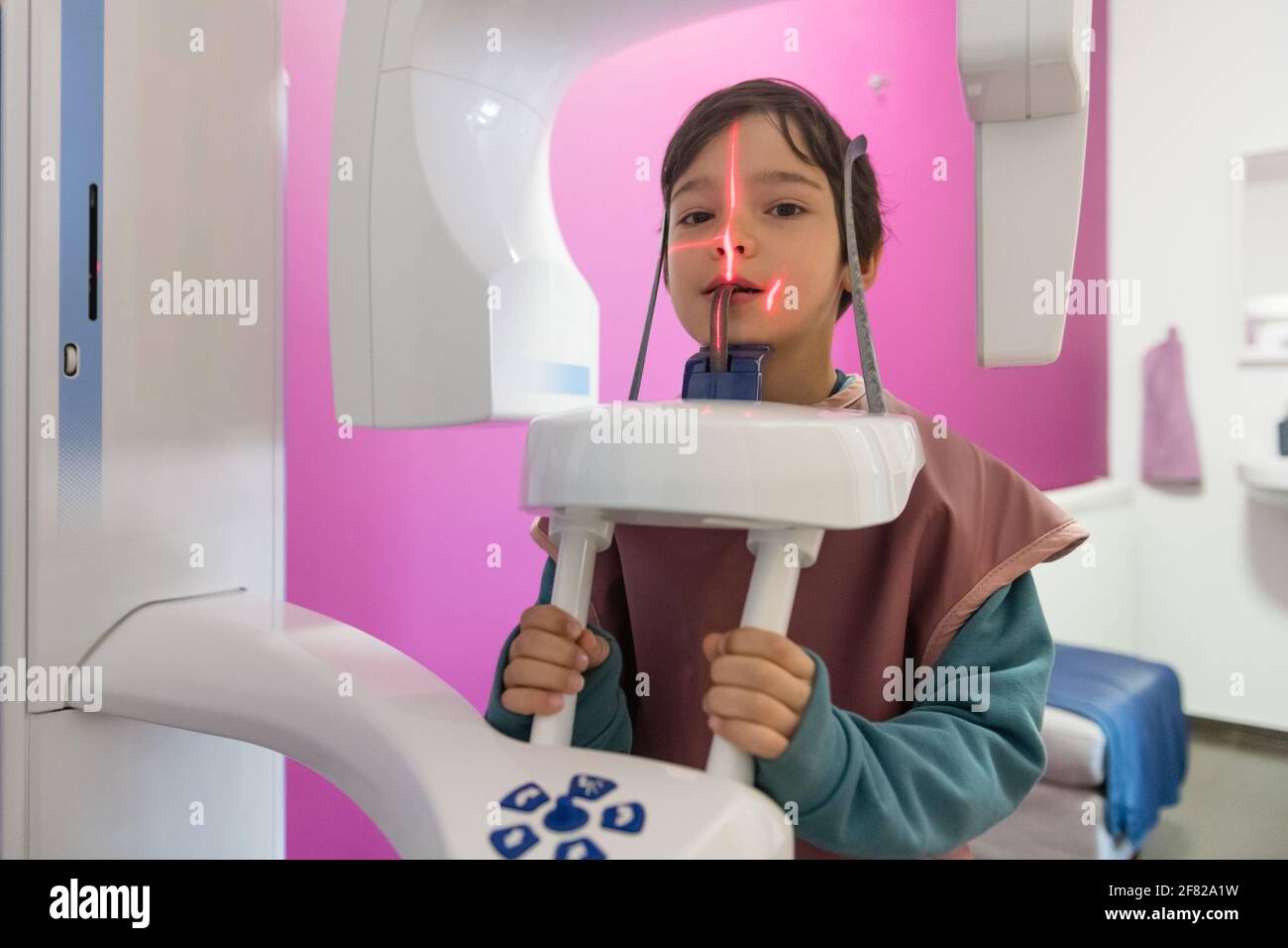 Jeune garçon en vêtement de protection faisant une photo panoramique de rayons X. une dent dans le cabinet dentaire Banque D'Images