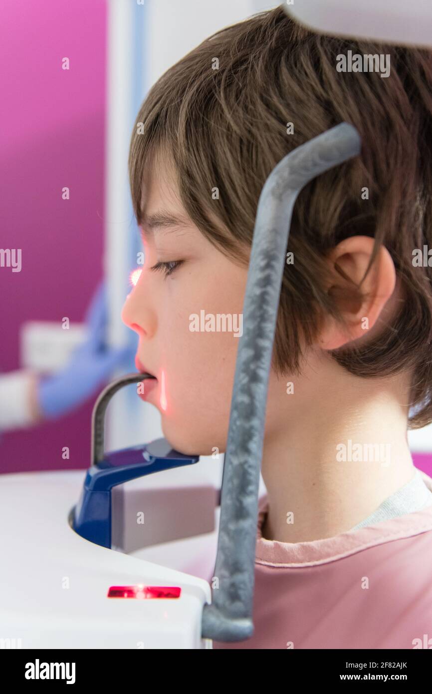 Jeune garçon en vêtement de protection faisant une photo panoramique de rayons X. une dent dans le cabinet dentaire Banque D'Images