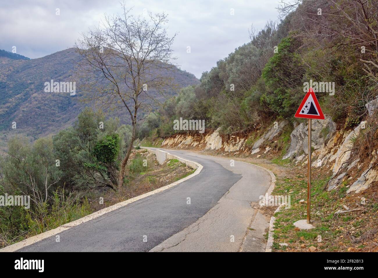 Route des Balkans. Ancienne route de campagne avec un signe de chute de pierres. Monténégro Banque D'Images