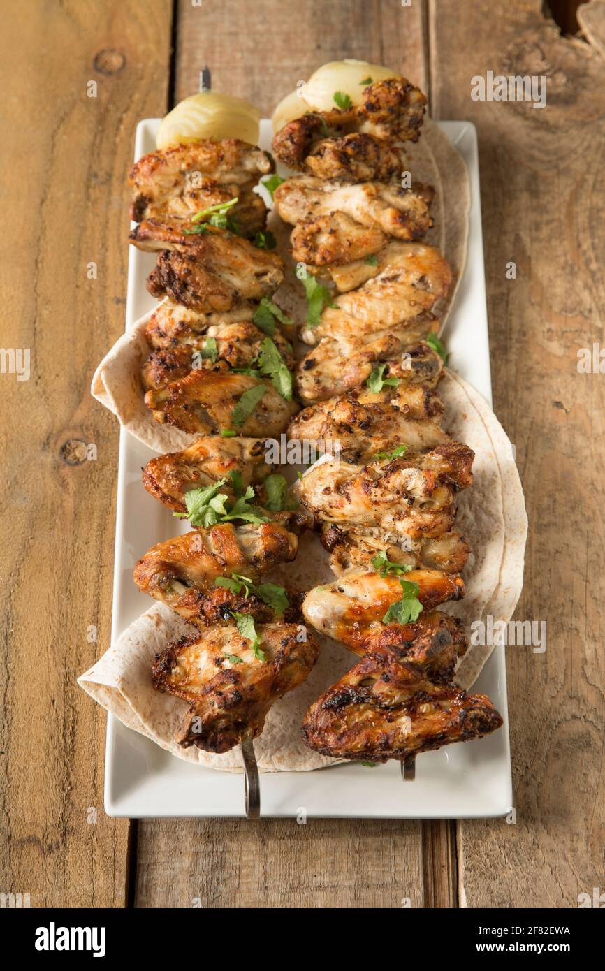 Les ailes de poulet britanniques qui ont été marinés dans les épices marocaines de Ras el Hanout avant d'être brochées et grillées à la maison. Angleterre GB Banque D'Images