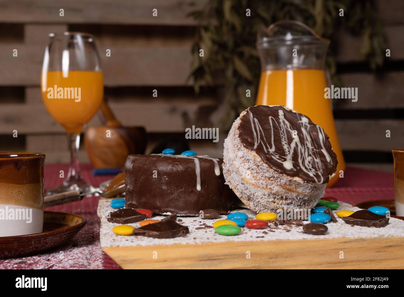 Un Petit Coup De Petits Gateaux Au Chocolat Avec Des Bonbons De Differents Couleurs Et Jus D Orange Sur La Table Photo Stock Alamy