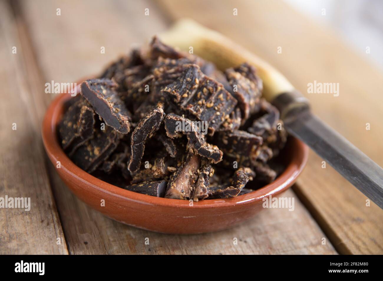 Des lanières de bœuf britannique hachées provenant d'une rôtissoire qui ont été séchées à l'air à la maison pour faire du biltong avec du sel, du sucre, du vinaigre brun et des épices y compris Banque D'Images