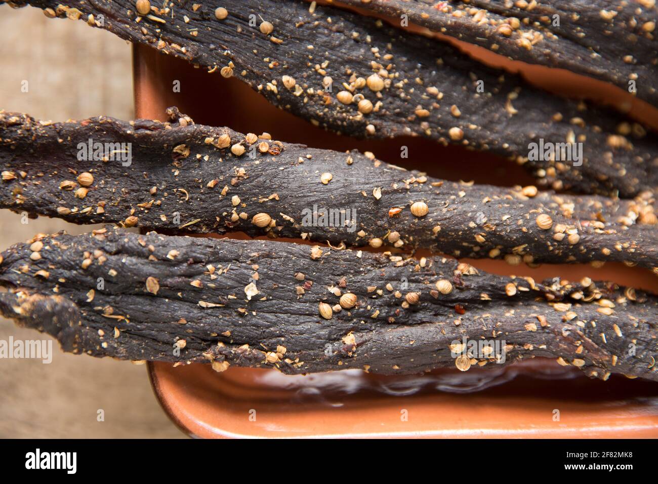 Des bandes de bœuf britannique provenant d'un joint de torréfaction qui ont été séchées à l'air à la maison pour faire du biltong avec du sel, du sucre, du vinaigre brun et des épices y compris le co Banque D'Images