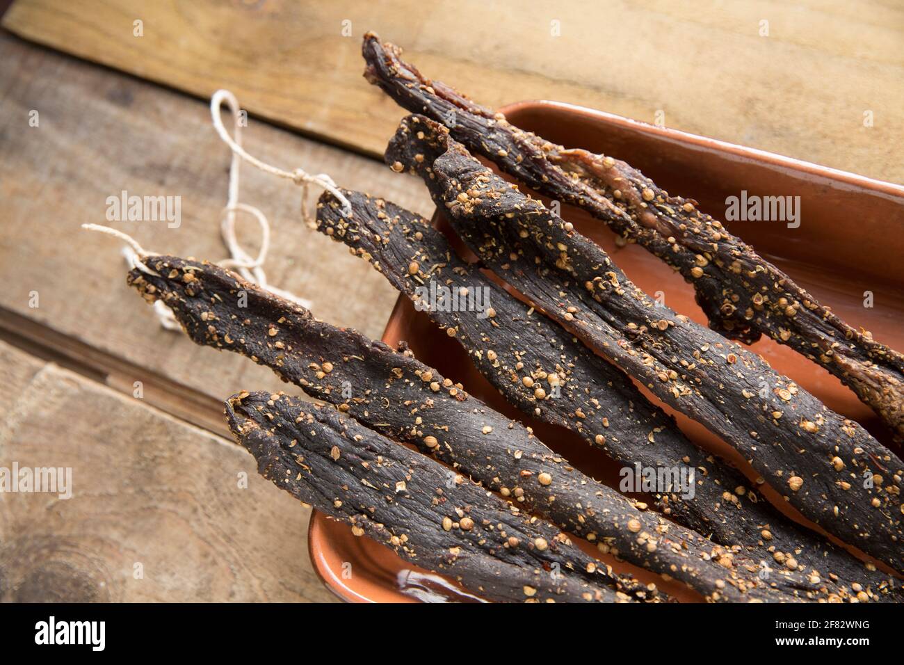 Des bandes de bœuf britannique provenant d'un joint de torréfaction qui ont été séchées à l'air à la maison pour faire du biltong avec du sel, du sucre, du vinaigre brun et des épices y compris le co Banque D'Images