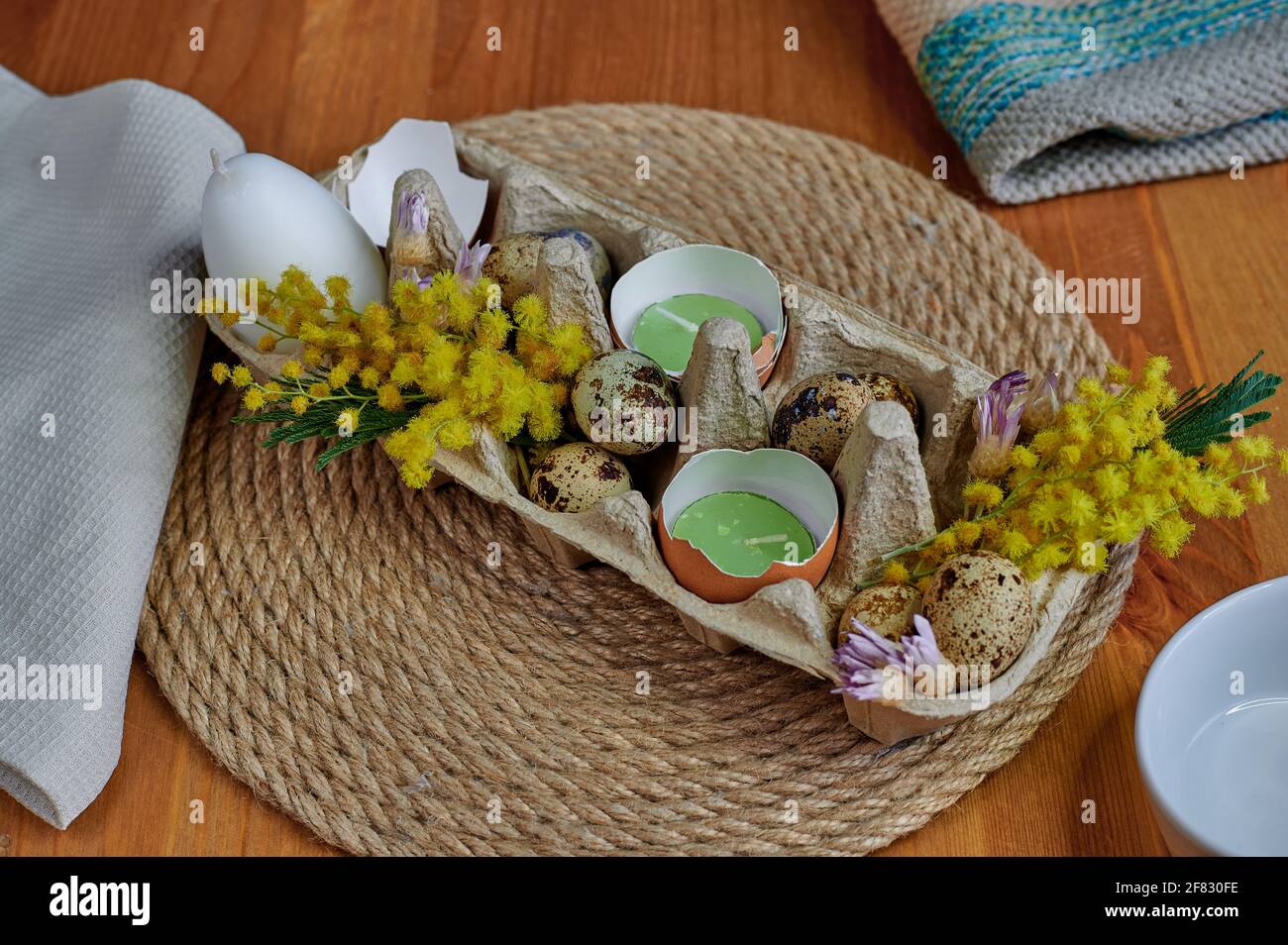 Décor de Pâques, mimosa, bougies aux œufs, coquilles d'œufs, fleurs séchées Banque D'Images
