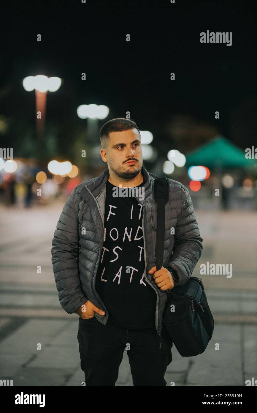 Un beau mâle caucasien marchant autour de la ville avec un sac la nuit Banque D'Images