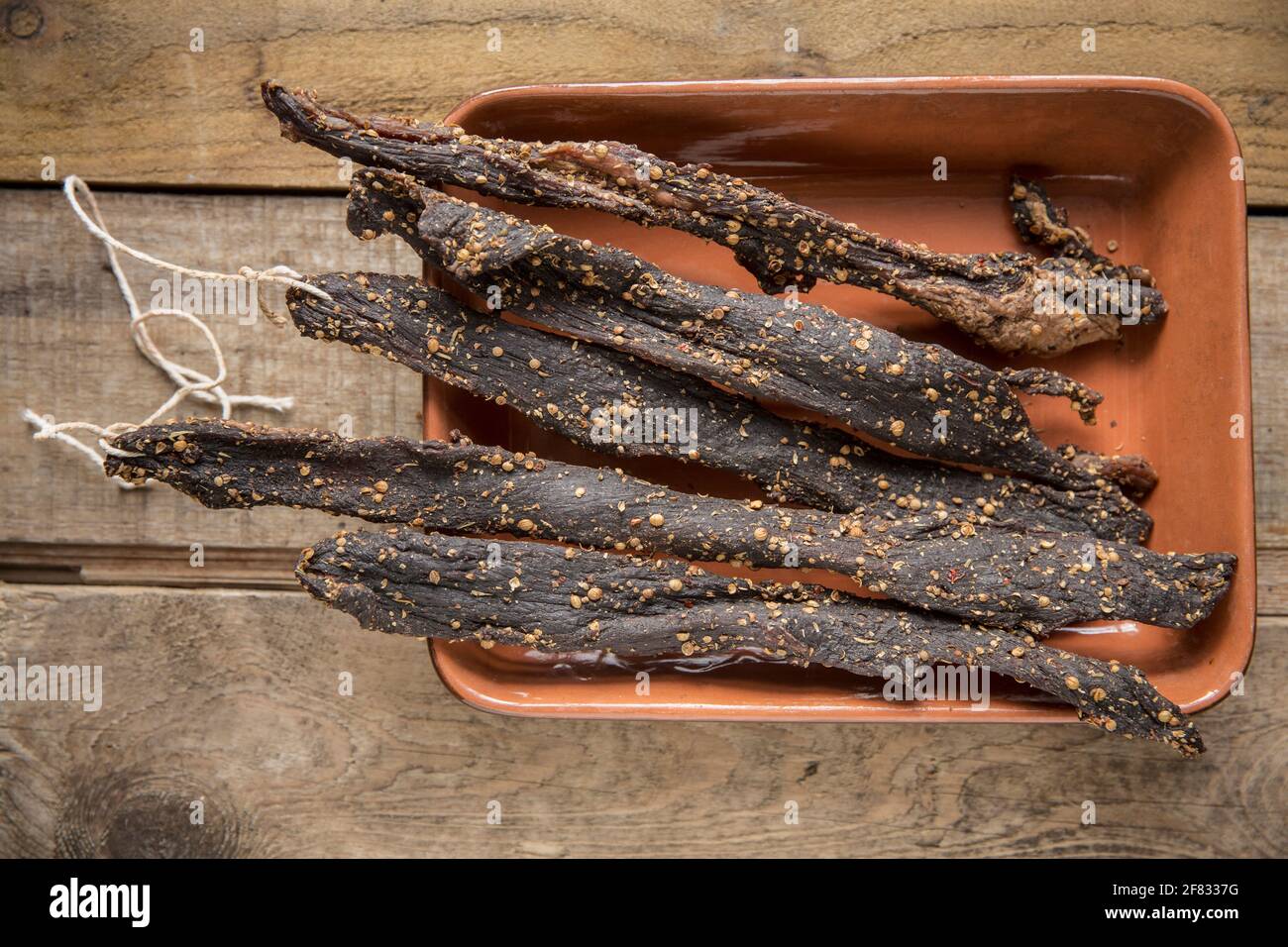 Des bandes de bœuf britannique provenant d'un joint de torréfaction qui ont été séchées à l'air à la maison pour faire du biltong avec du sel, du sucre, du vinaigre brun et des épices y compris le co Banque D'Images