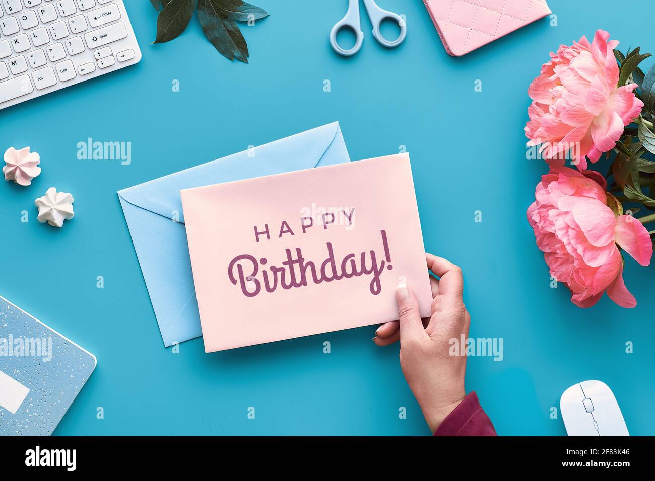 Motif Carte De Vœux D Anniversaire Main Avec Stylo Bureau A Domicile Texte Joyeux Anniversaire Sur Carte Papier Fleurs De Pivoine Rose Sur Table De Menthe Bleue Bureau A Domicile Remarque Photo Stock