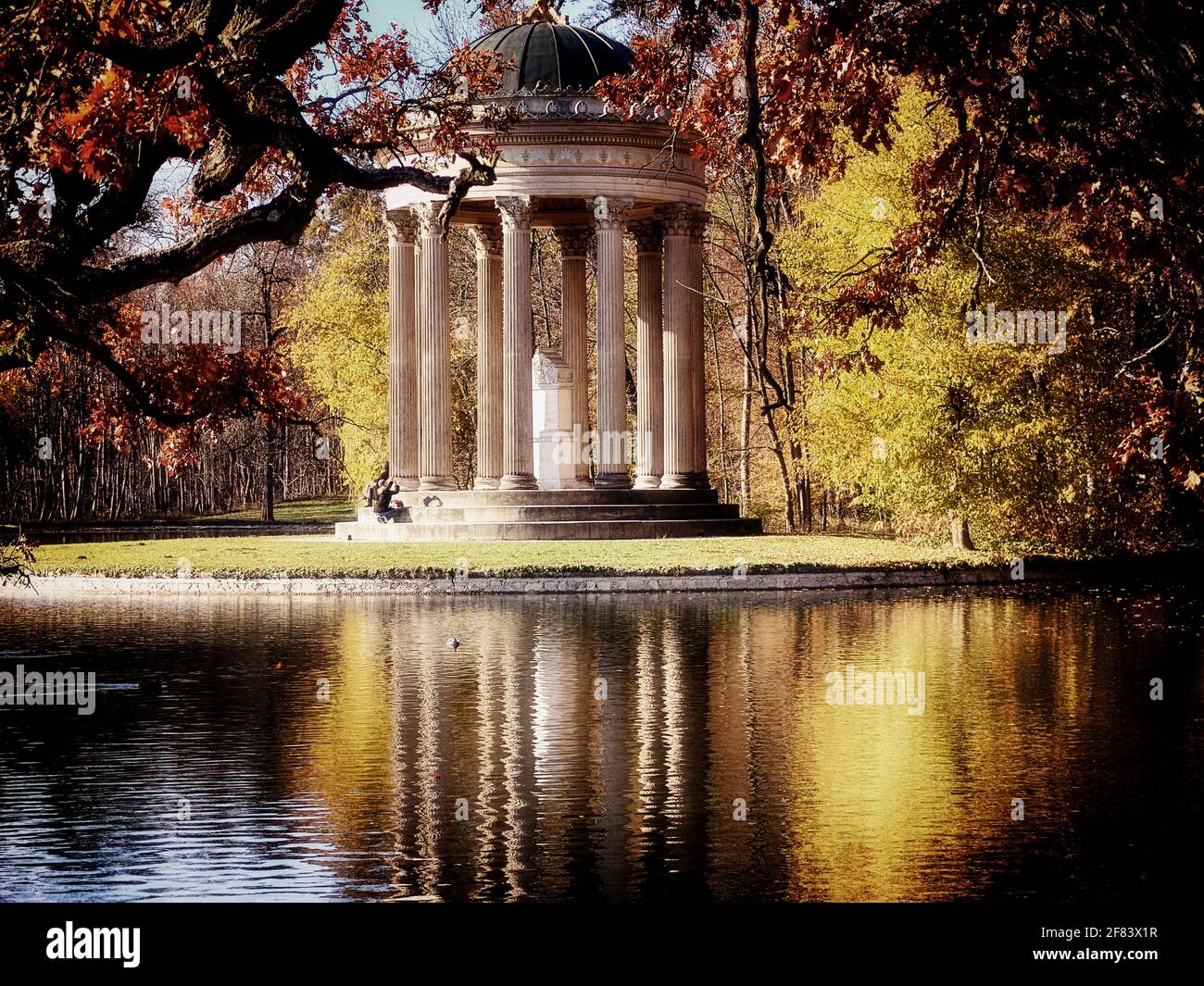 Munich, le parc du château de Nymphenburg résidence des rois bavarois : vue suggestive sur les monopteros, temple circulaire en marbre d'Apollon encadré de feuilles rouges Banque D'Images