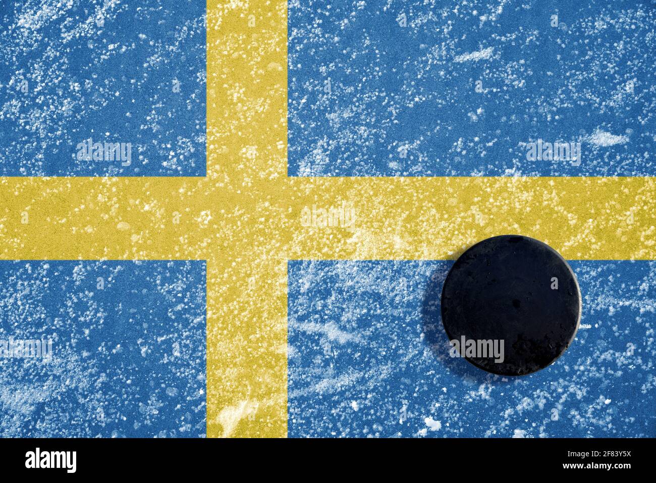 Palet de hockey noir sur glace avec drapeau suédois. Banque D'Images