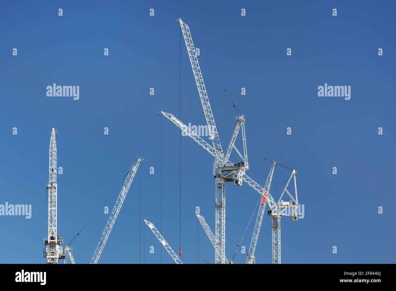 Grues blanches de construction contre le ciel bleu dans un site de construction à Londres, Royaume-Uni Banque D'Images