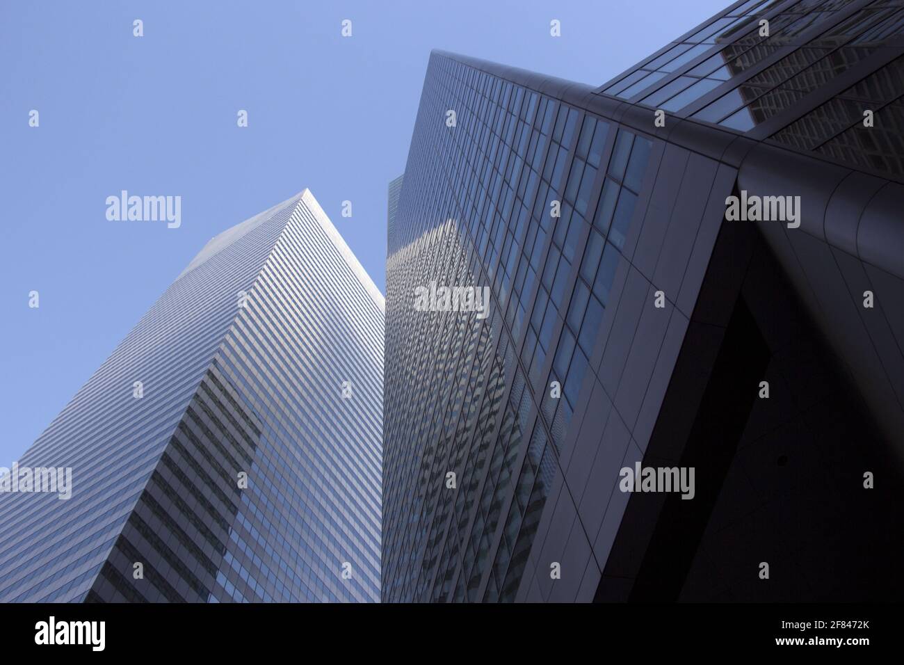 Vue à angle bas des bâtiments d'une ville. Gratte-ciels modernes avec extérieur en verre s'élevant vers un ciel bleu. Banque D'Images