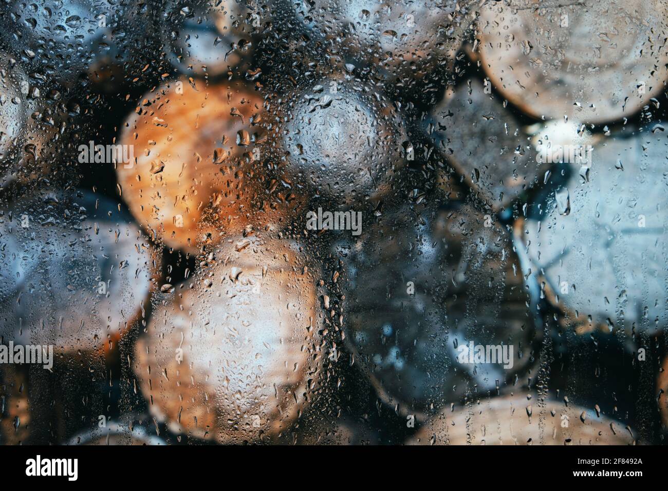 Verre après pluie en gouttes sur un fond flou de rondins, bois rond Banque D'Images