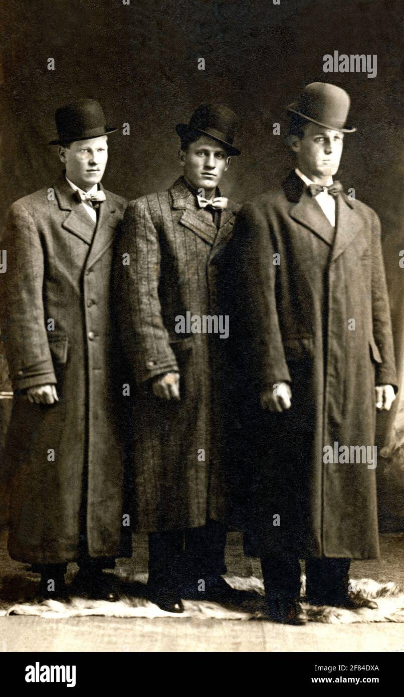 Image photographique d'archives de 3 hommes portant des pardessus et des chapeaux melons vers 1910. Banque D'Images