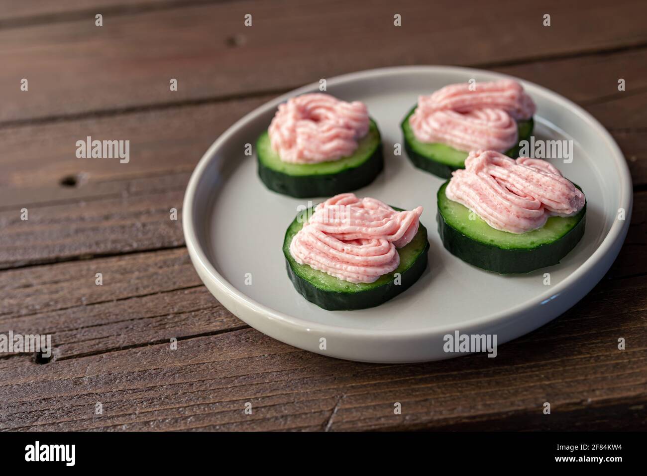 Toasts au concombre et au tarama sur une assiette grise sur une table en bois foncé, gros plan Banque D'Images