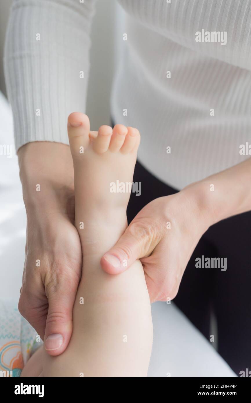 Maman Donne A Son Bebe Un Massage Des Jambes Et Des Pieds Gros Plan Un Bebe Satisfait Se Trouve Sur La Table De Massage Photo Stock Alamy