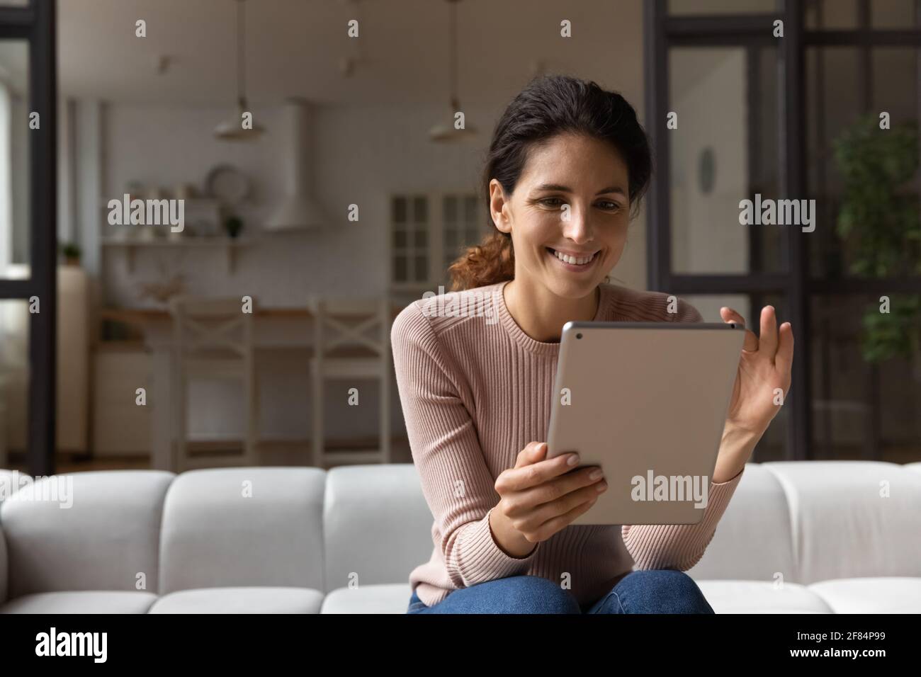 Femme latine confiante tient le zoom de la tablette sur l'image à l'écran Banque D'Images