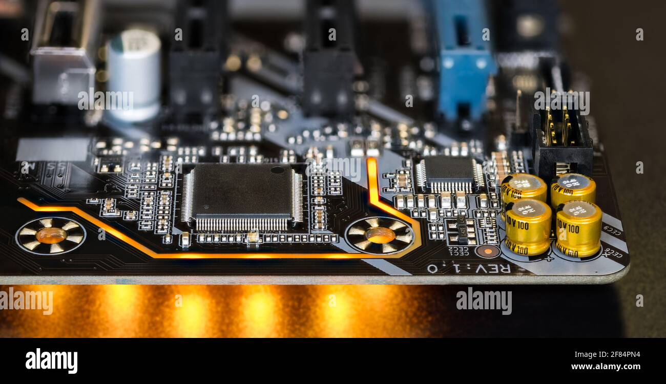 Carte de circuit imprimé sur les détails de la carte mère de l'ordinateur moderne. Composants électroniques. Micro-puces, condensateurs, résistances. LA LED s'allume sur fond noir. Banque D'Images