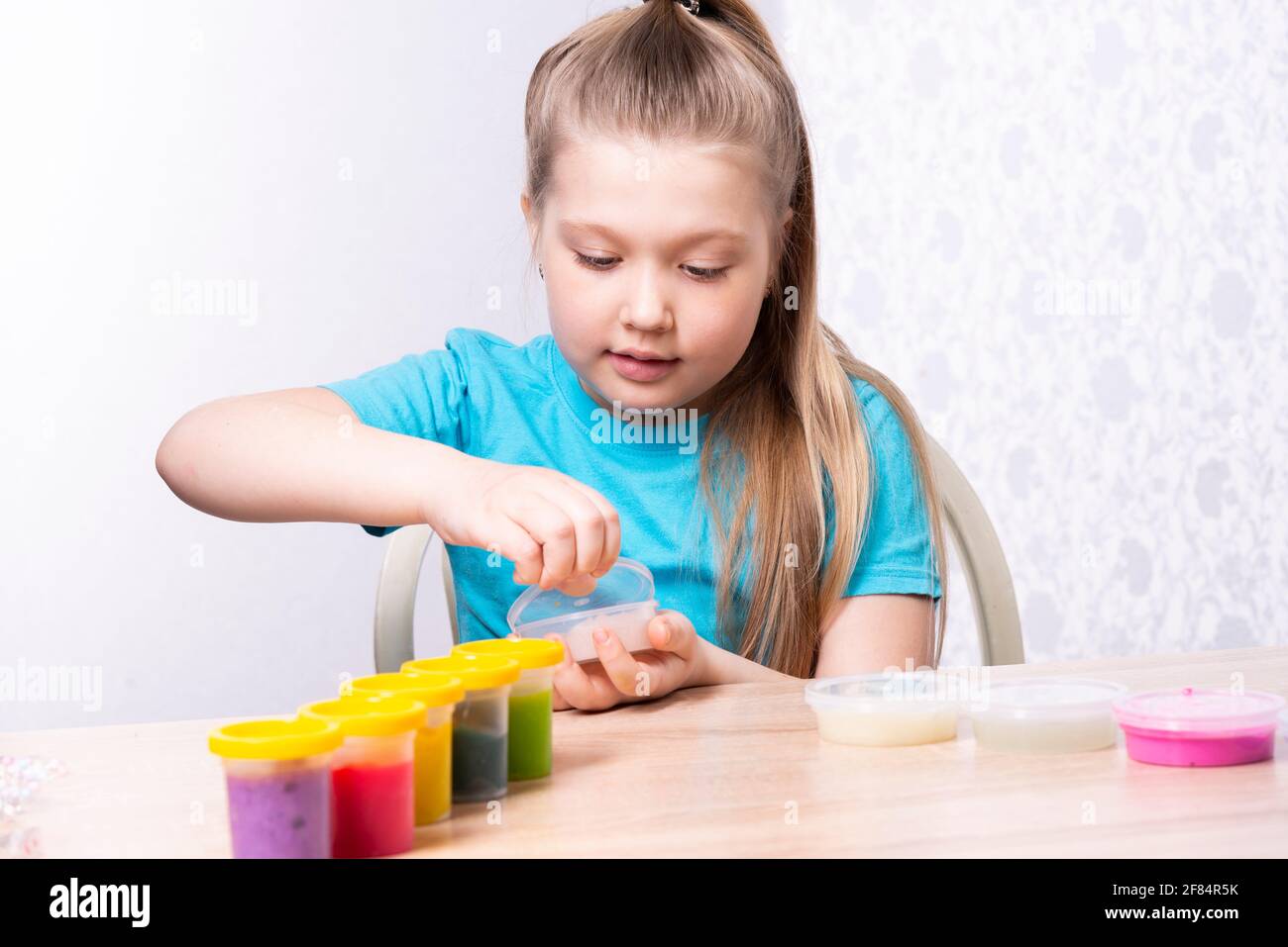 Un Enfant Blond Joue Avec Un Slime. Petite Belle Fille Caucasienne