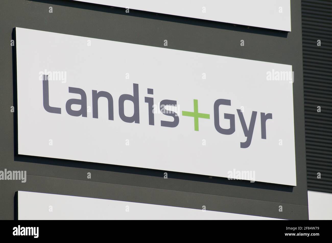Zug, Suisse - 28 mars 2021 : signalisation Landis + Gyr suspendue devant le bâtiment du siège de Zug. Landis + Gyr est une société cotée en bourse, Banque D'Images