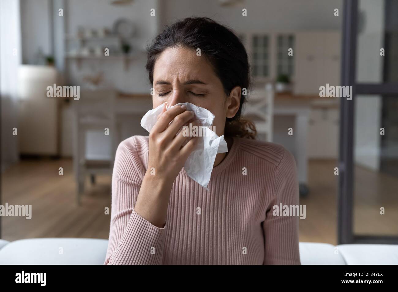 Une dame de latina malade attrape le nez froid dans le papier-mouchoir Banque D'Images