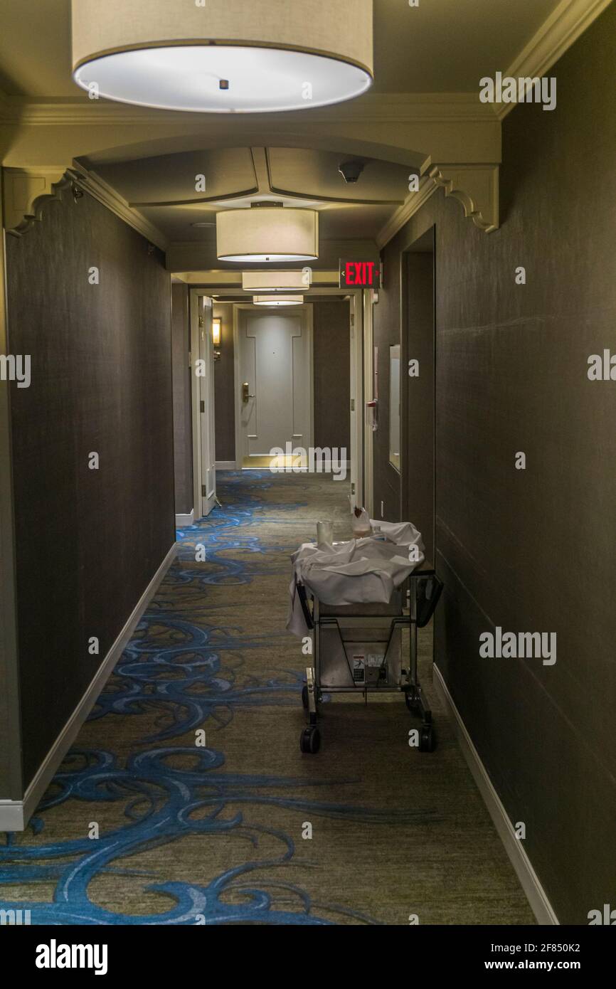 Chariot avec fournitures de salle et équipement de nettoyage à faible éclairage couloir de l'hôtel Banque D'Images