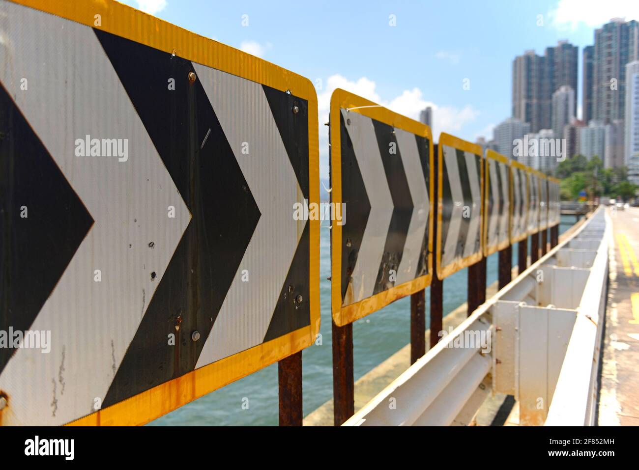 Les flèches en face du port dirigent les voitures le long de la route du front de mer et empêchent les voitures de se rendre dans l'eau à Kennedy Town, Hong Kong, Chine Banque D'Images