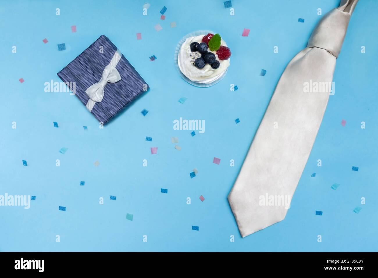 Boîte cadeau bleue avec cravate blanche, gâteau blanc sur fond bleu avec  confettis de couleur. Concept de fête des pères, félicitations à un homme,  un fils, un collègue Photo Stock - Alamy