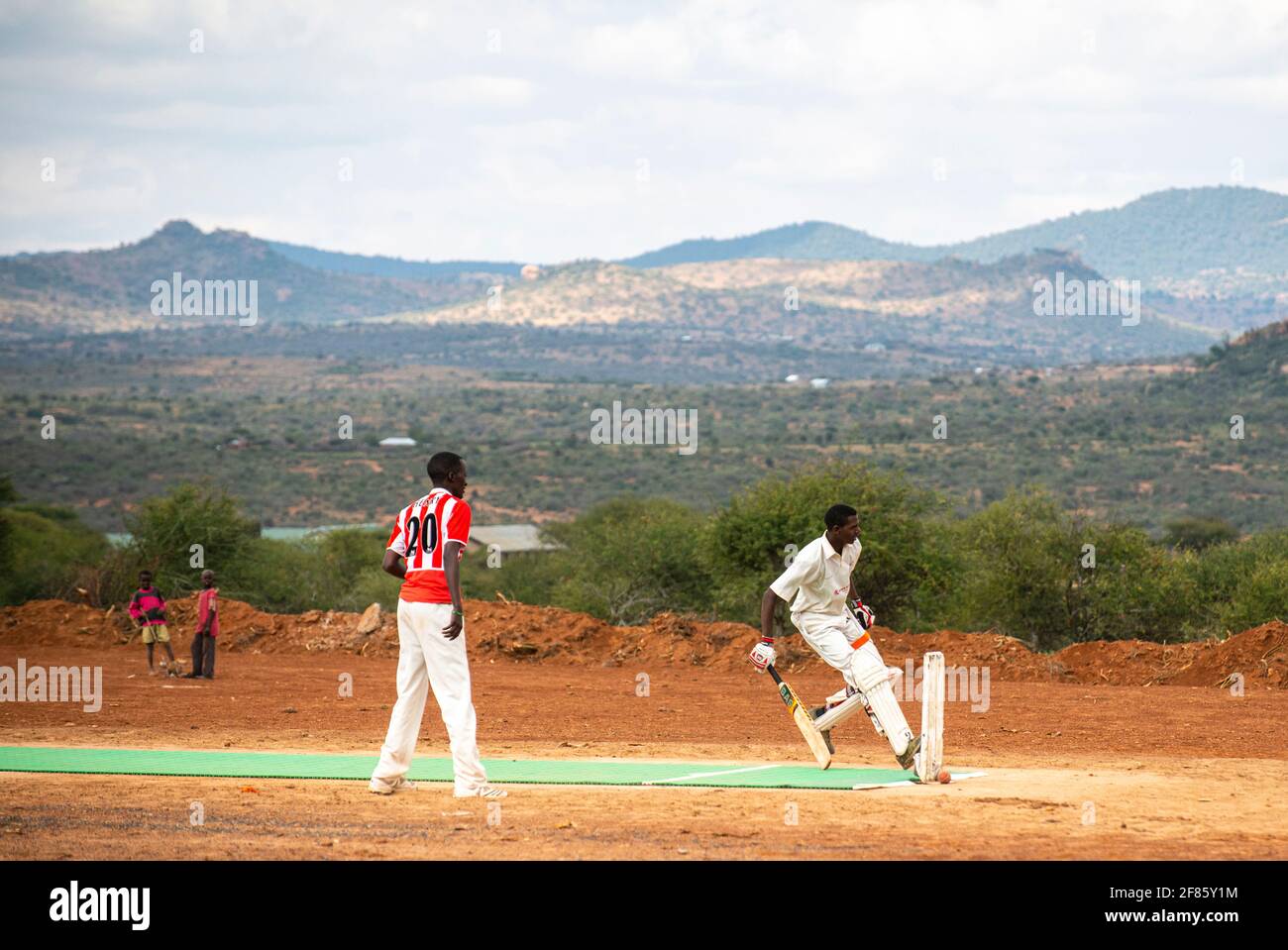 Des hommes jouant au cricket au Kenya près de Nanyuki sur terre champ Banque D'Images