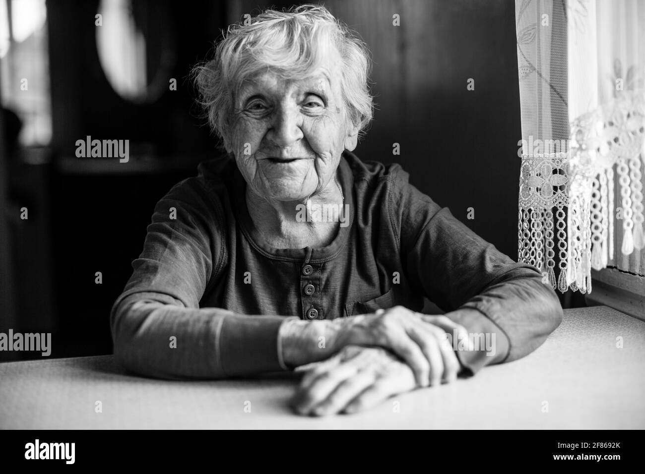 Portrait d'une vieille femme pensionnée dans sa maison. Photo en noir et blanc. Banque D'Images