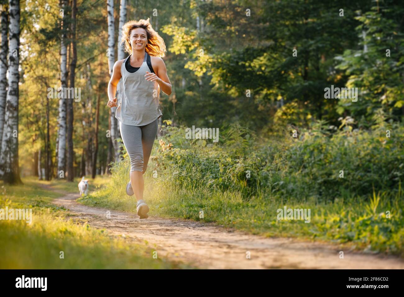 Une jeune fille sportive est engagée dans la forme physique dans la forêt d'été. Banque D'Images