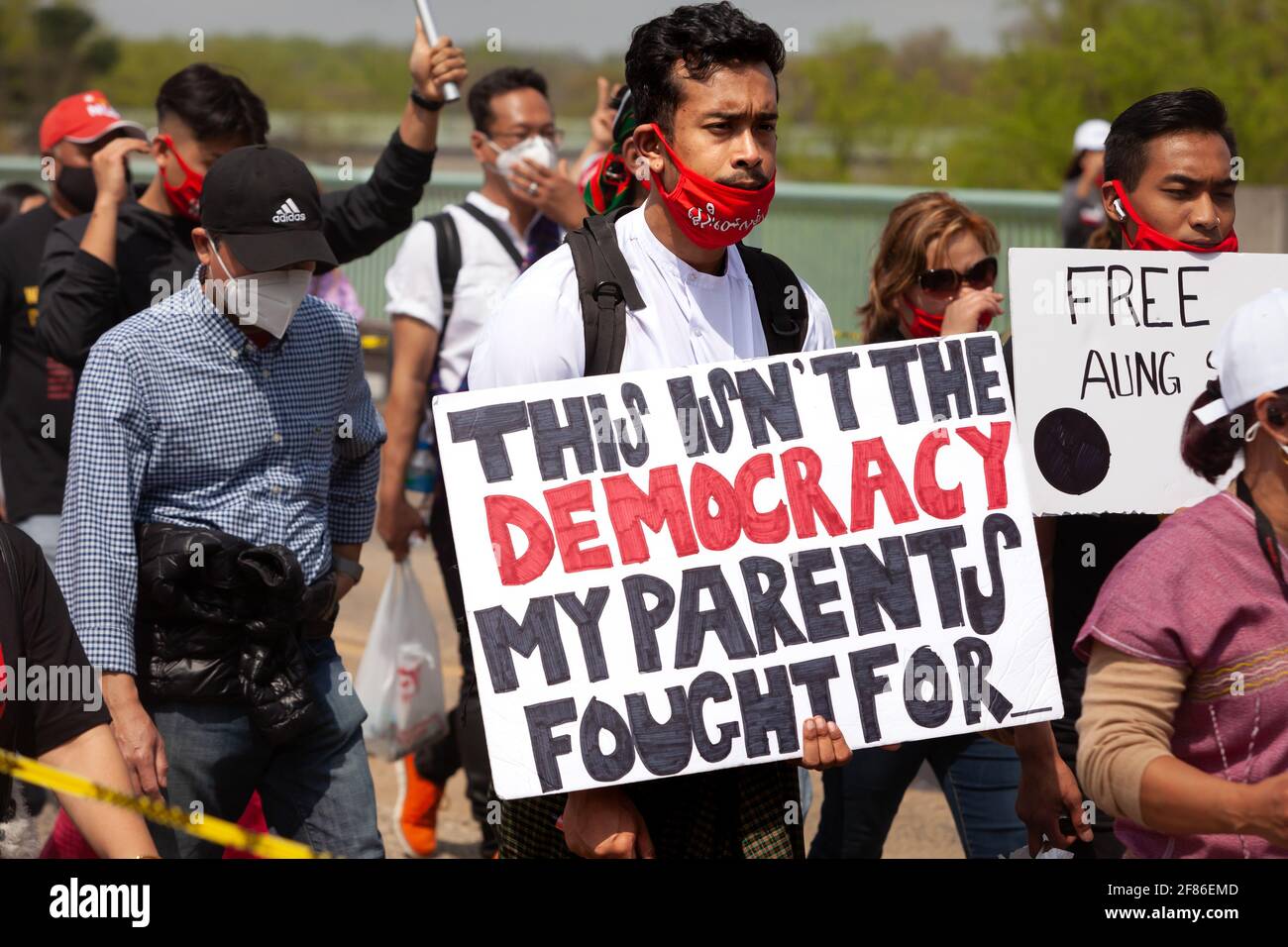 Un jeune homme porte un signe faisant référence aux sacrifices de ses parents pour la démocratie lors d'une marche contre le coup d'État en Birmanie. Banque D'Images