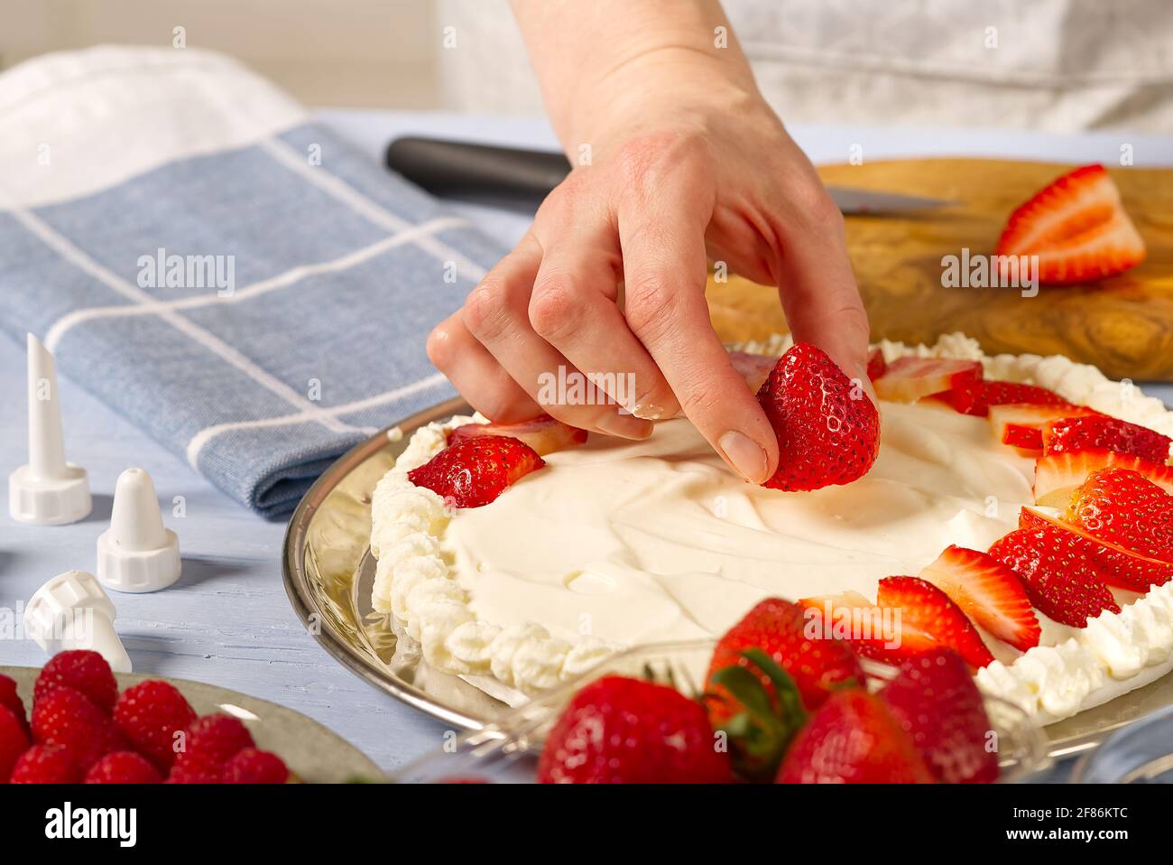 Femme Boulanger Empile Les Fraises Sur La Base De Gateau A La Fraise Meringue Gateau Aux Fraises Fait Maison A Base De Gateau Meringue Et De Creme Aux Fraises Photo Stock