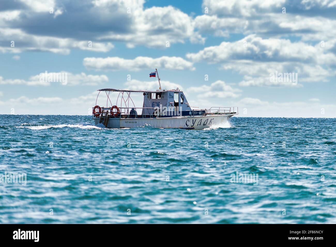 Bateau blanc rapide navigue par la mer. Jour d'automne ensoleillé. Vue latérale. Crimée, Sudak - 10 octobre 2020. Banque D'Images