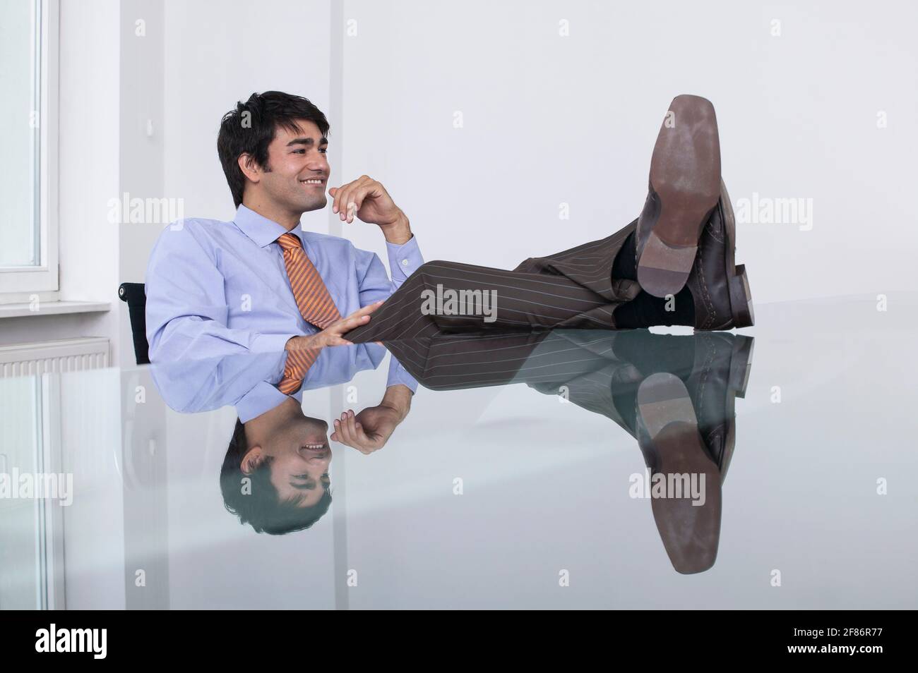 Homme d'affaires insouciant avec ses pieds dans la salle de conférence Banque D'Images