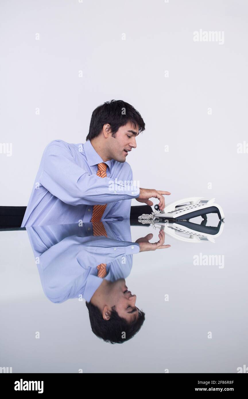 Homme d'affaires utilisant le téléphone de conférence dans la salle de conférence Banque D'Images