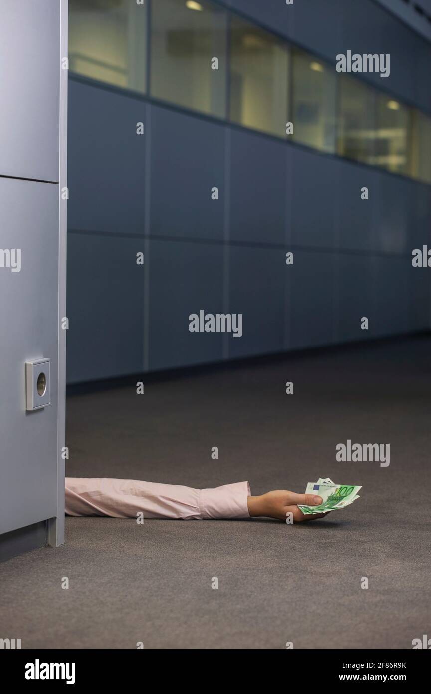 Bras de femme d'affaires tenant de l'argent dans le bureau Banque D'Images