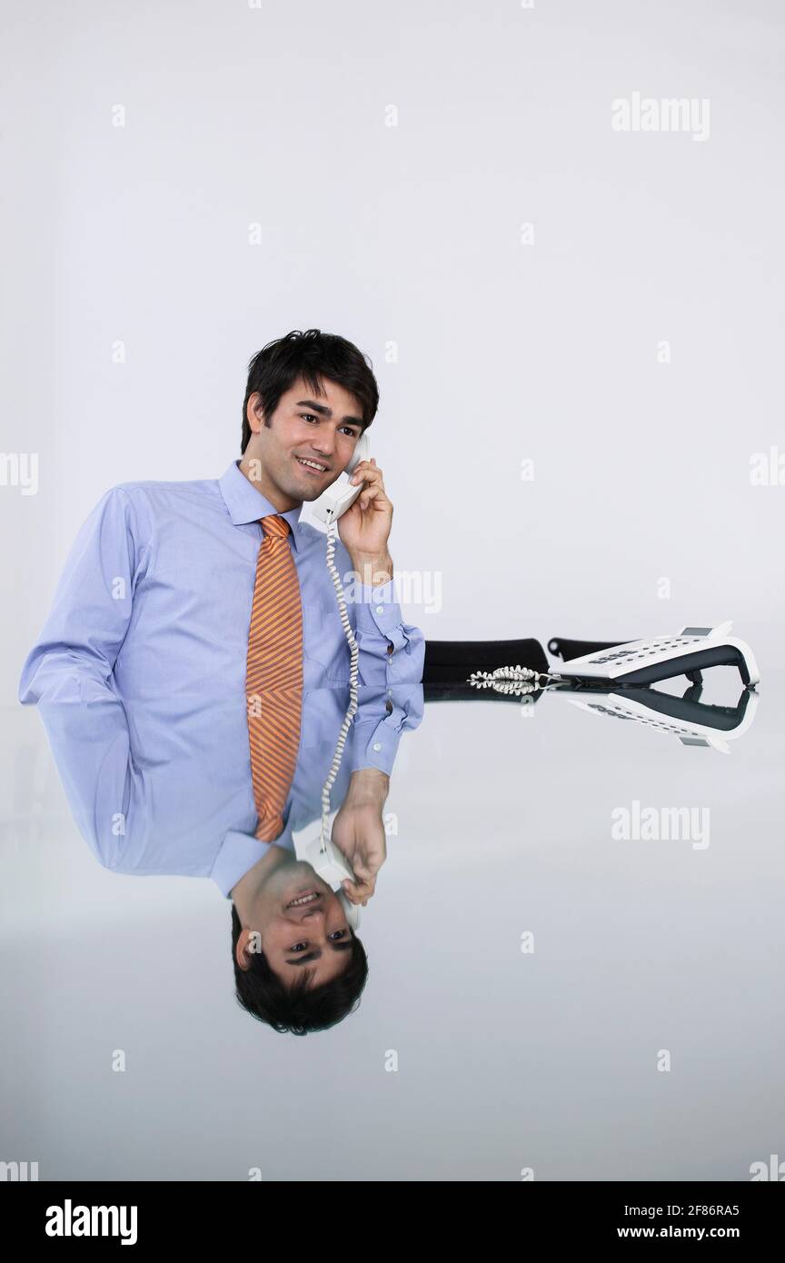 Homme d'affaires souriant parlant au téléphone de conférence dans la salle de conférence Banque D'Images