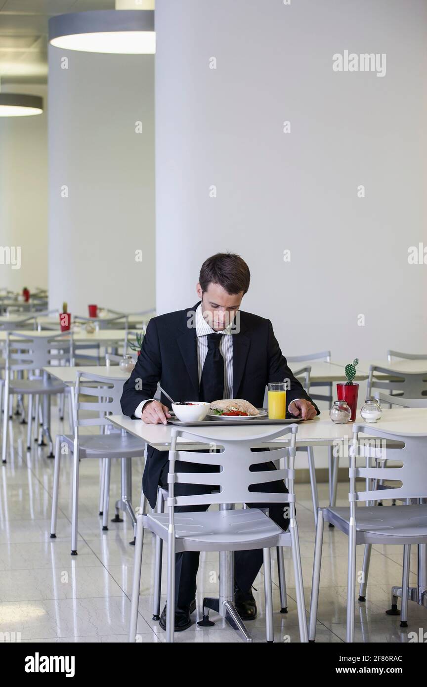 Homme d'affaires regardant le plateau du déjeuner dans la cafétéria du bureau Banque D'Images