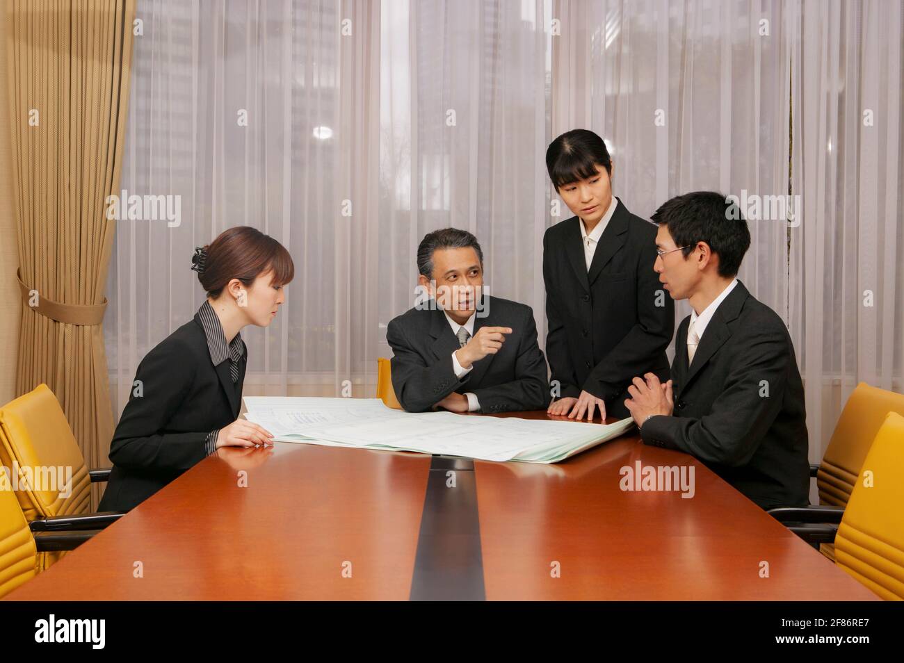 Des professionnels discutent de plans dans la salle de conférence de bureau Banque D'Images