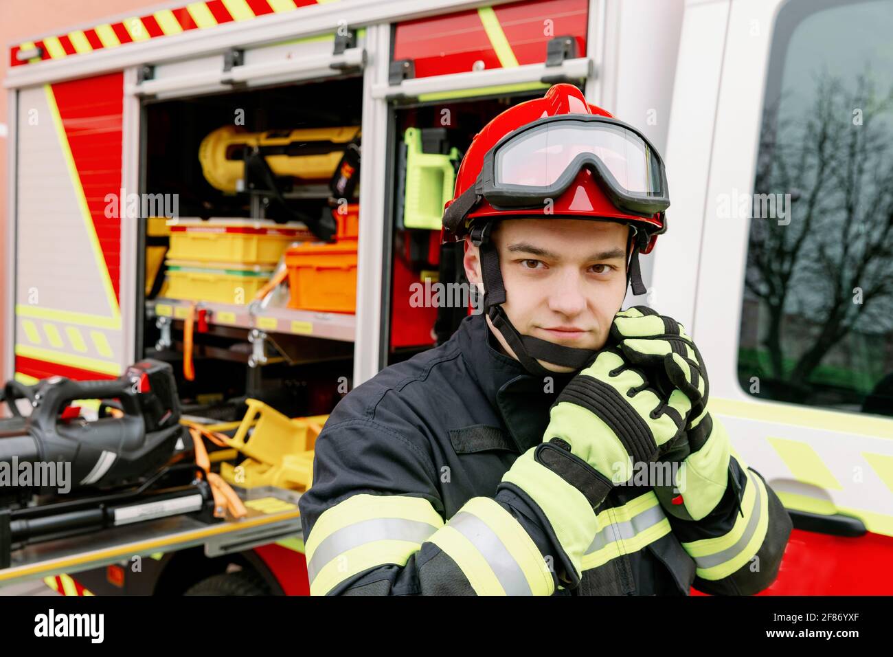 Un homme de physique fort en uniforme et un casque se tient près d'un  véhicule de secours. Homme secouriste Photo Stock - Alamy