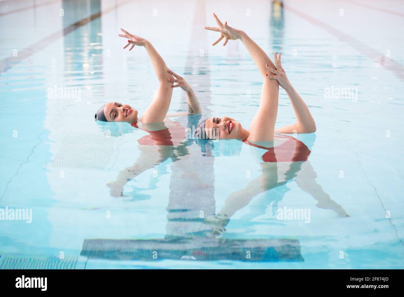 Rebecca Richardson (à gauche) et Geneviève Florence, membres de l'équipe de natation synchronisée Aquabatix au cours d'une séance d'entraînement dans la piscine du Clissold Leisure Centre, dans le nord de Londres, qui a rouvert au public alors que l'Angleterre repart vers la normalité avec l'assouplissement supplémentaire des restrictions de verrouillage. Date de la photo: Lundi 12 avril 2021. Banque D'Images