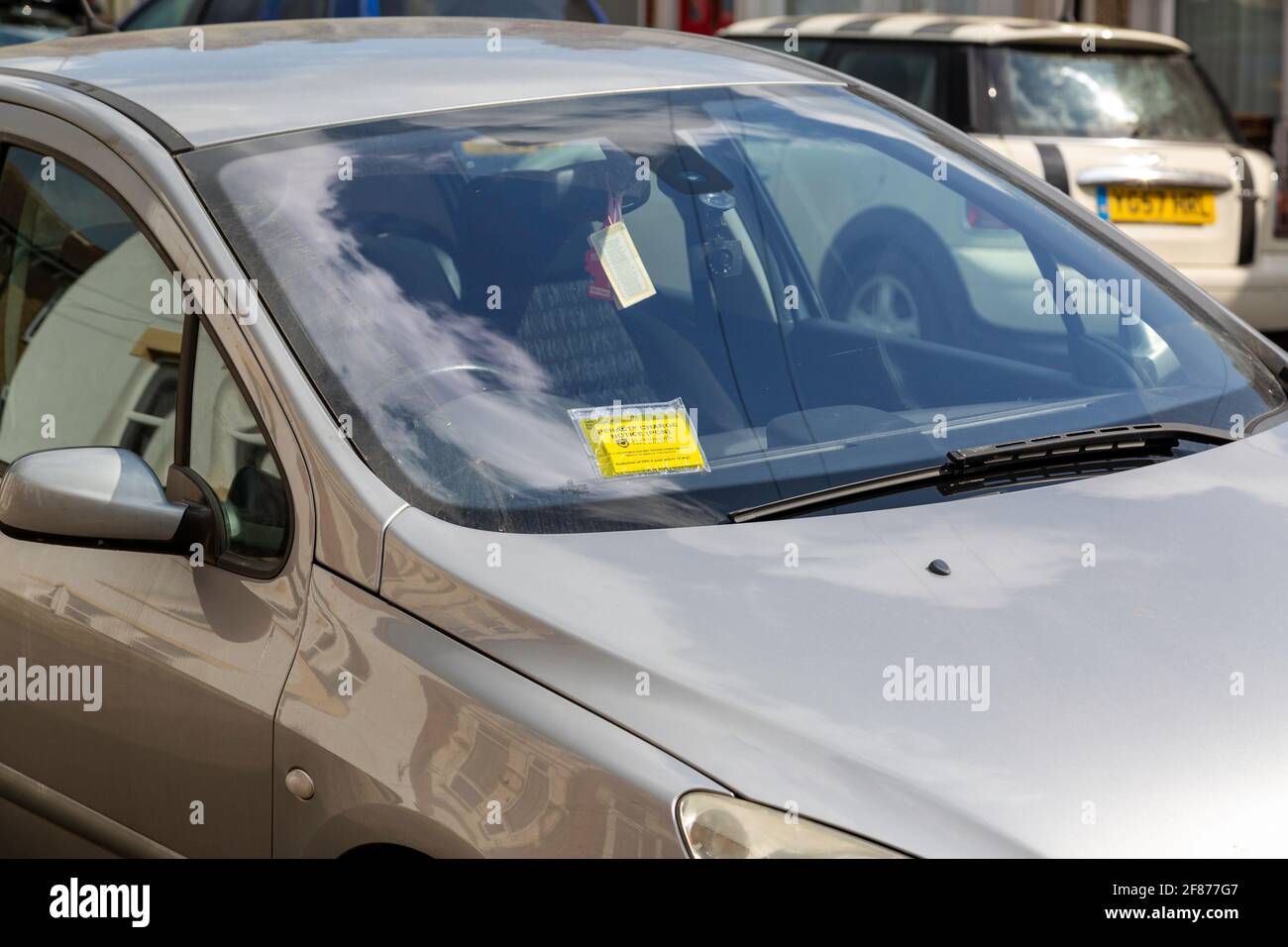 Une voiture garée illégalement dans une rue avec un parking billet collé sur le pare-brise Banque D'Images